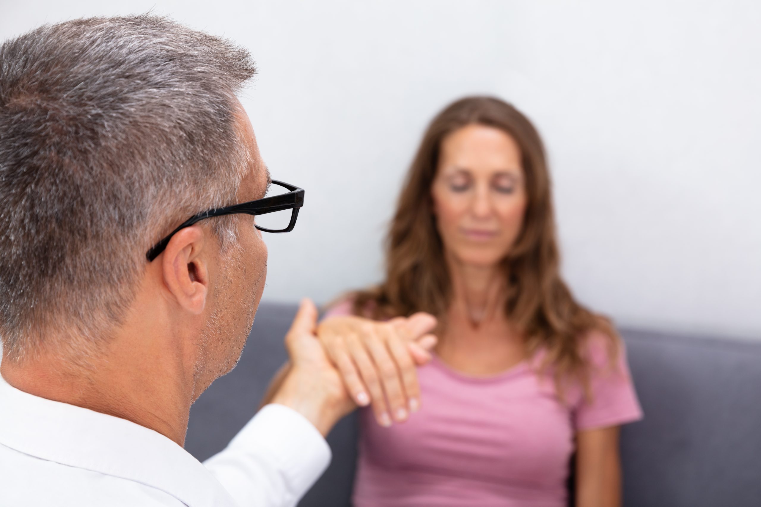 A compassionate doctor holding a woman's hand, providing comfort and support during a medical consultation